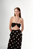 Model wearing the Polka Dots Bandeau Top  front color black, made with 100% viscose fabric, styled for resortwear look 
