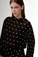 Model wearing the Polka Dots Long Sleeve Maxi Dress detail showcasing its black color on 100% Viscose fabric, styled for an evening look.  