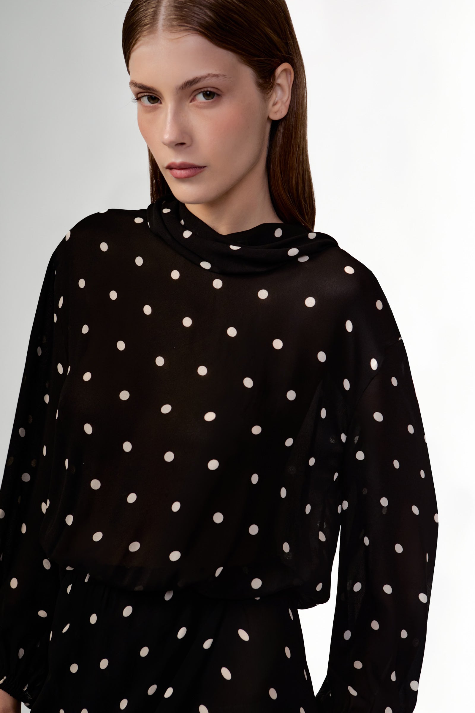 Model wearing the Polka Dots Long Sleeve Maxi Dress detail showcasing its black color on 100% Viscose fabric, styled for an evening look.  