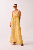 Model wearing the Polka Dots Maxi Dress front color cashew yellow, made from 55% linen 45% viscose, styled for a resort look