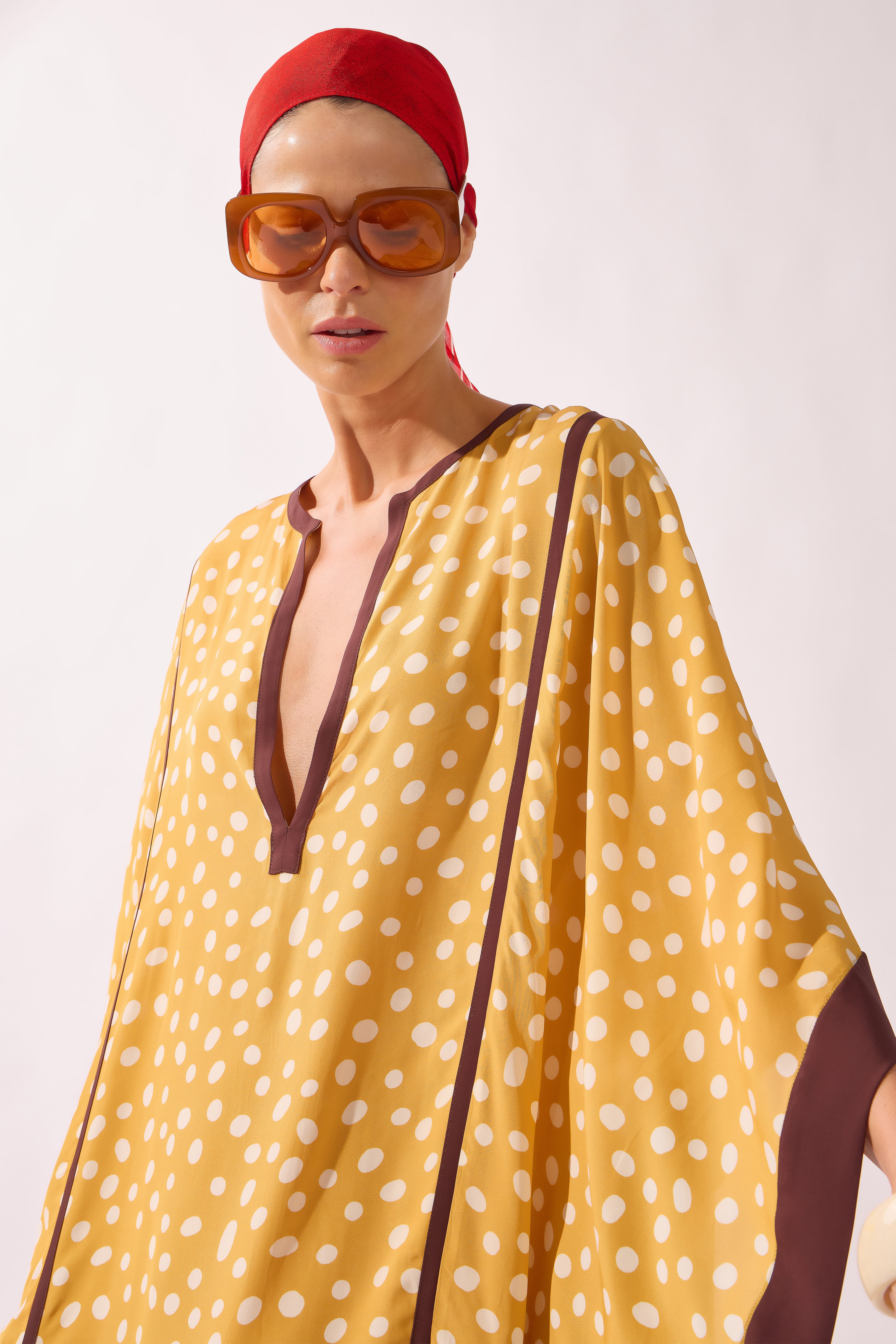Model waering the Polka Dots Maxi Kaftan detail, showcasing its yellow 100% viscose fabric, styled for a resort look.