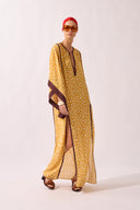 Model waering the Polka Dots Maxi Kaftan look, showcasing its yellow 100% viscose fabric, styled for a resort look.