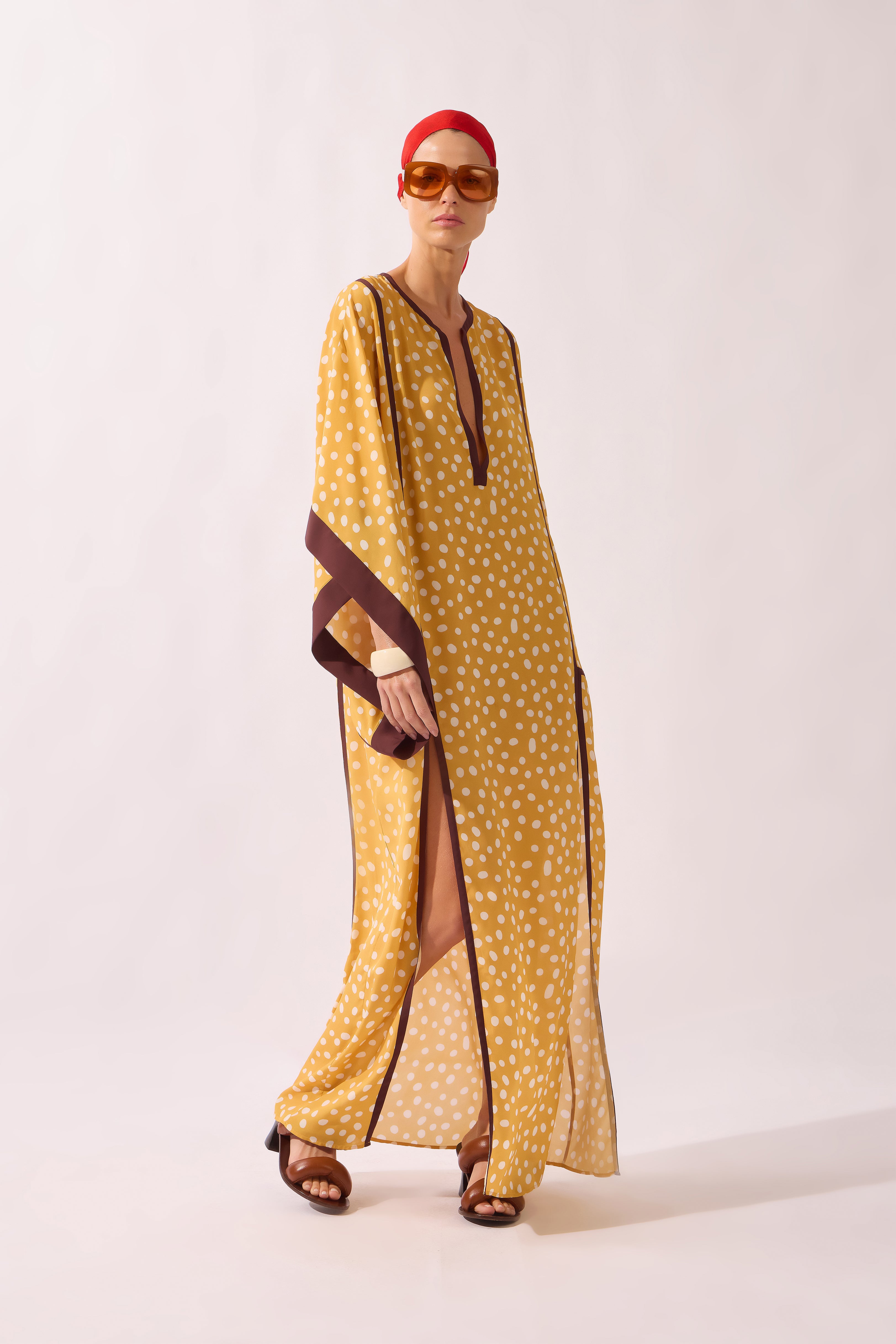 Model waering the Polka Dots Maxi Kaftan look, showcasing its yellow 100% viscose fabric, styled for a resort look.