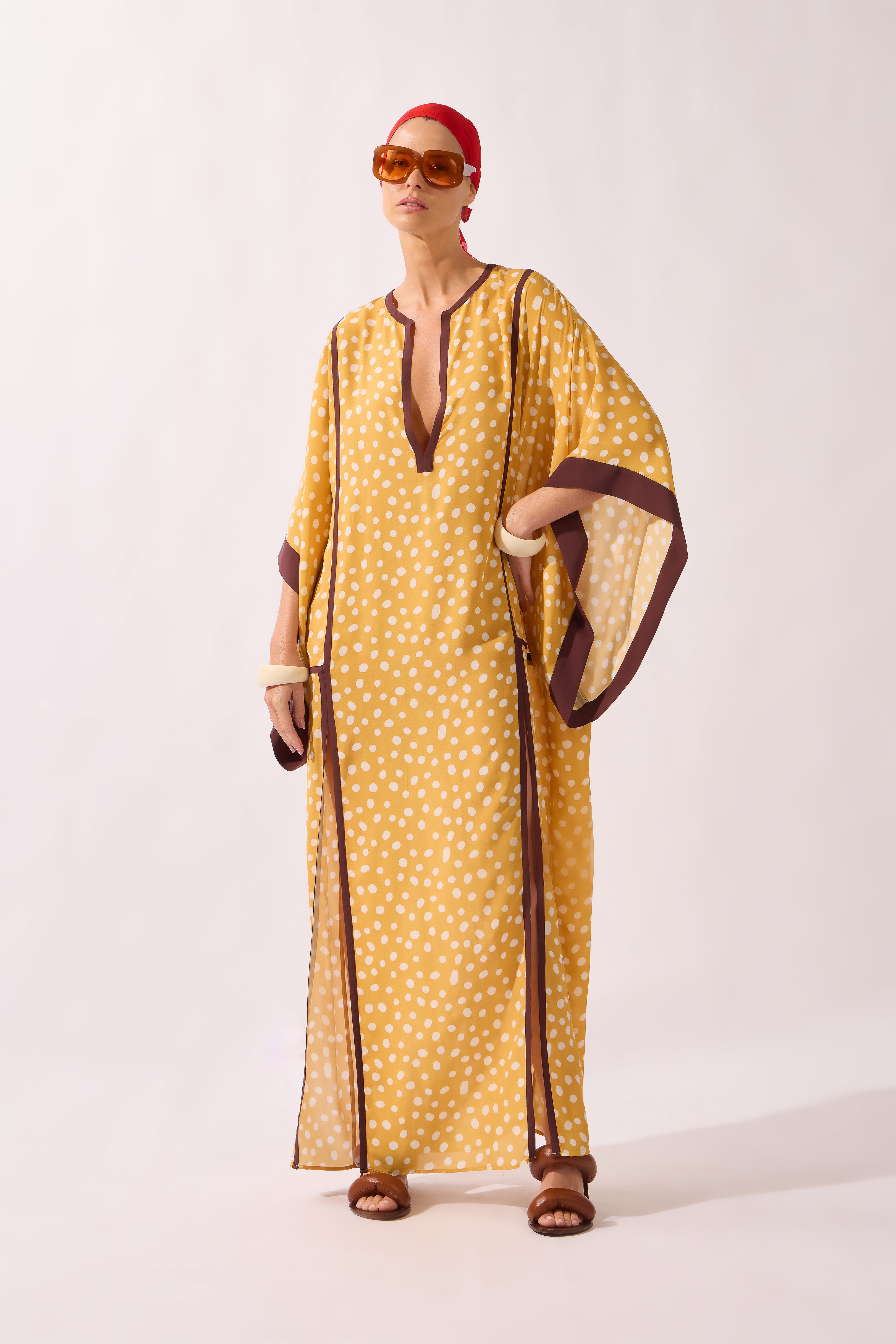 Model waering the Polka Dots Maxi Kaftan pose, showcasing its yellow 100% viscose fabric, styled for a resort look.