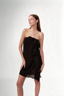 Model wearing the Polka Dots Mini Dress front color black, made with 100% viscose fabric, styled for resortwear look 