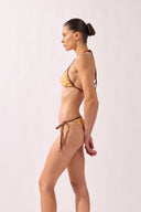 Model wearing the Polka Dots Triangle Bikini side color cashew yellow, made from 85% polyamide 15% elastane, styled for a beachwear look