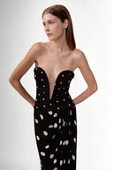 Model wearing the Polka Dots V-Neck Strapless Maxi Dress detail showcasing its black color on 100% Viscose fabric, styled for an evening look.  