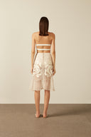 Model wearing the Réseau Appliqué Midi Skirt Back showcasing its Off White color on 100% Polyester fabric.  