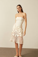 Model wearing the Réseau Appliqué Midi Skirt Front showcasing its Off White color on 100% Polyester fabric.  