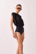 Model wearing the Ruched Swimsuit detail color black, made from 100% polyamide, styled for a beachwear look