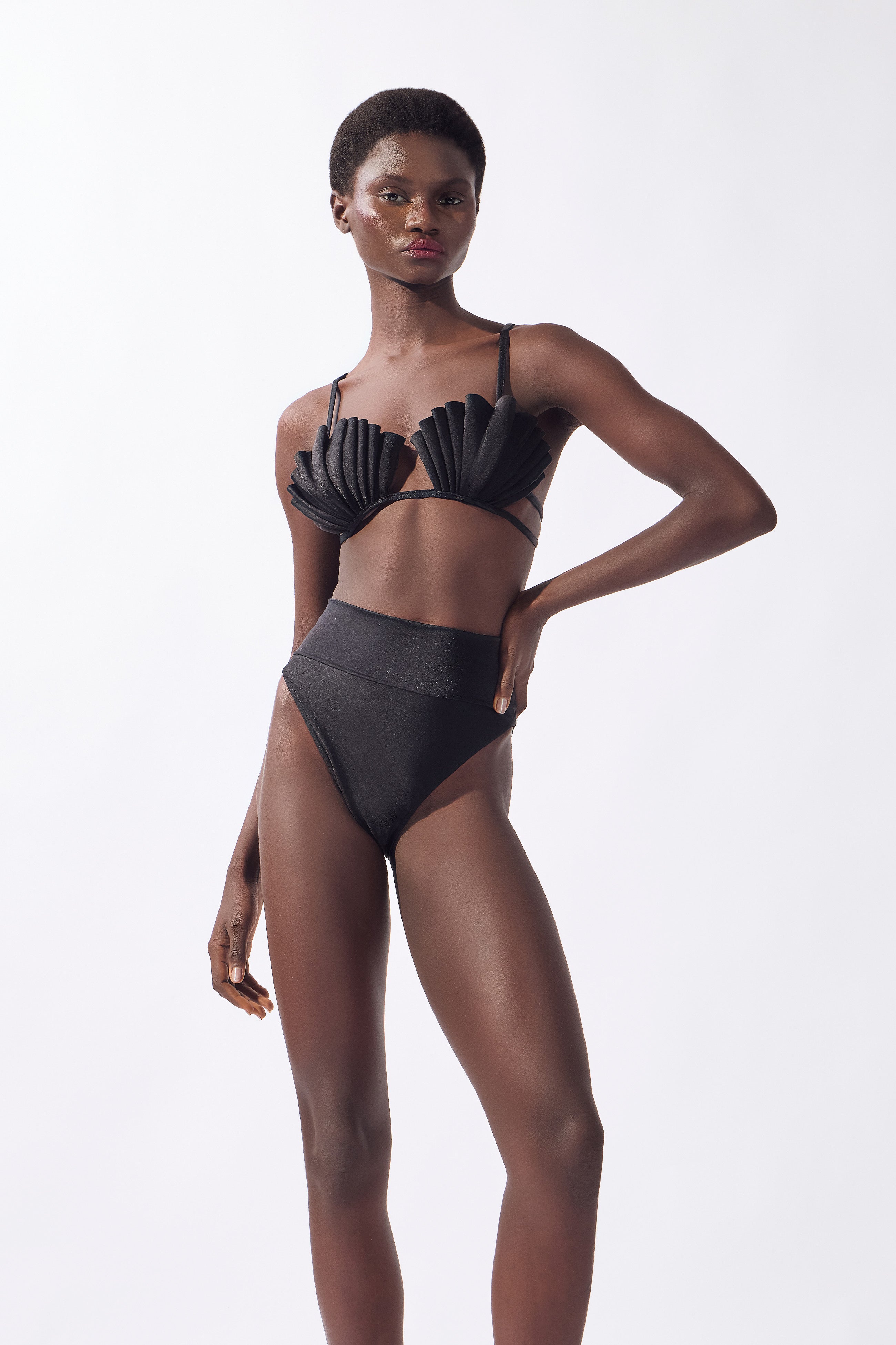 Model wearing the Seashell High-Leg Bikini Set color black made from 85% polyamide, 15% elastane, styled for a beachwear look