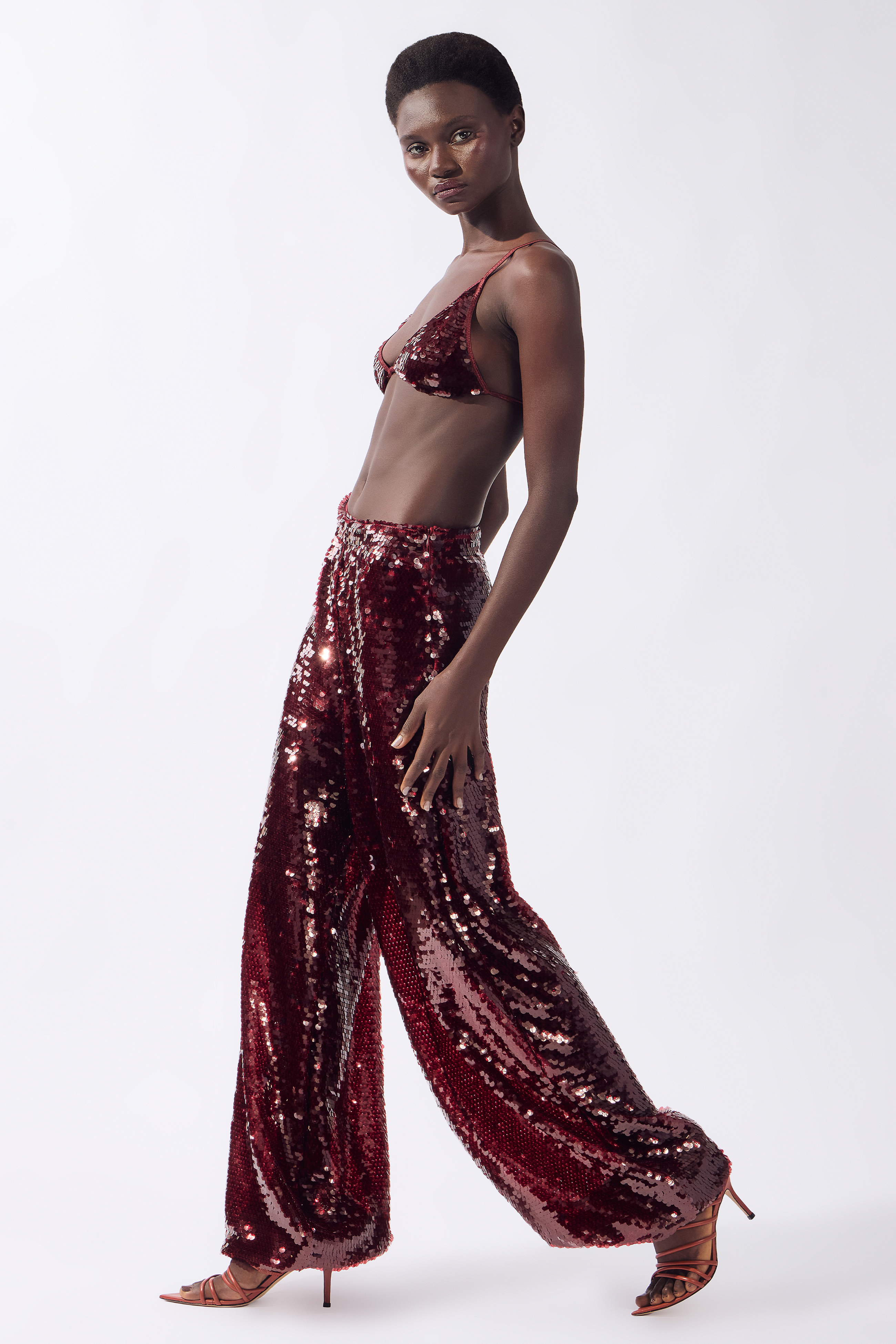 Model wearing the Sequin Bubble Pants color burgundy, made from 100% polyester, styled for a festive look