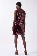 Model wearing the Sequin Mini Dress back color burgundy, made from 100% polyester, stuyled for a festive look
