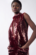 Model wearing the Sequin Mini Dress detail color burgundy, made from 100% polyester, stuyled for a festive look