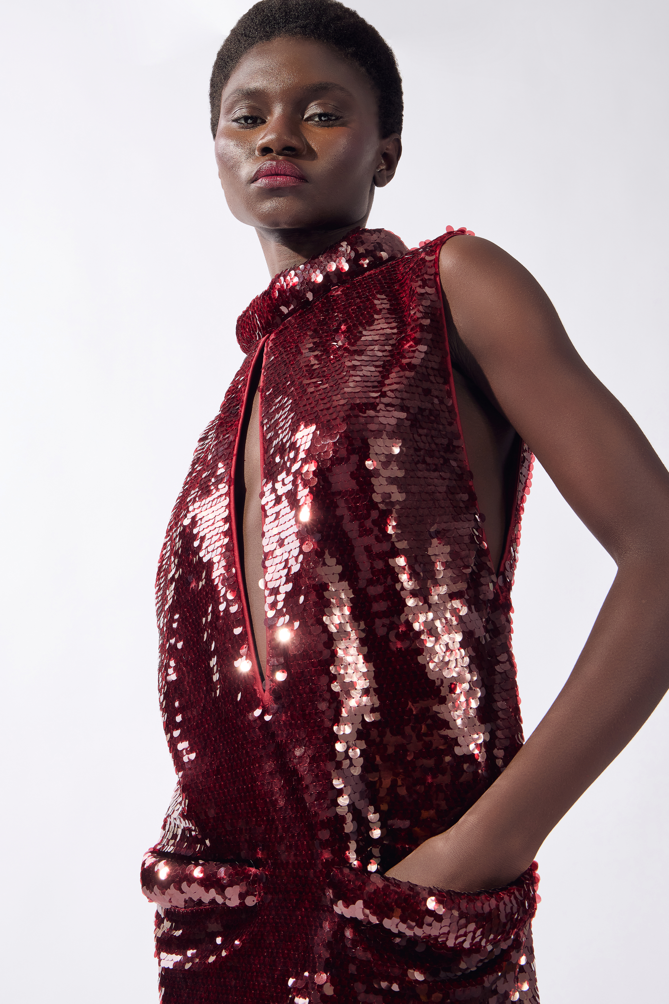 Model wearing the Sequin Mini Dress detail color burgundy, made from 100% polyester, stuyled for a festive look