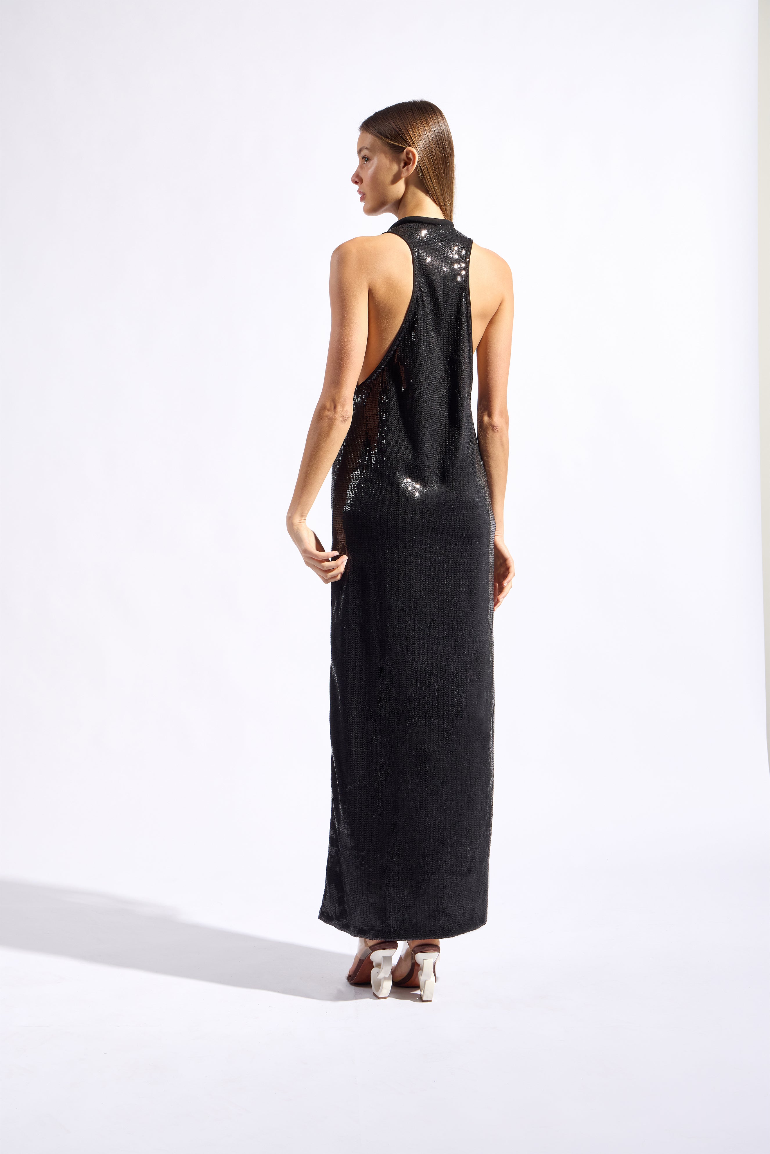 Model wearing the Sequin Plunge Maxi Dress back color black made with 96% Polyester 4% Elastane fabric, styled for a dinner look 