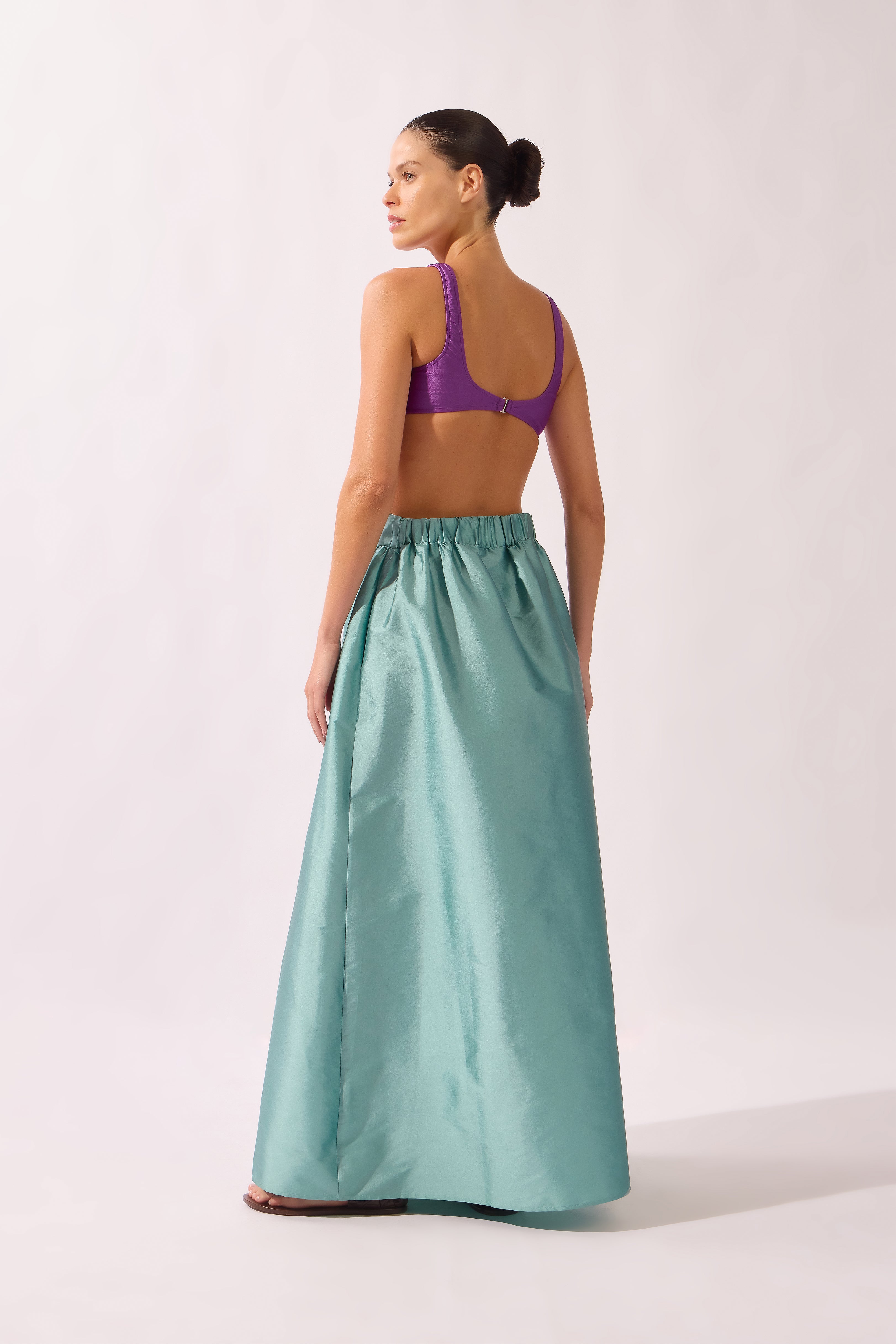 Model wearing the Side-Slit Maxi Skirt back color aquamarine made with 100% polyetser, styled for an post-beach look