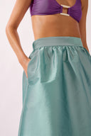 Model wearing the Side-Slit Maxi Skirt detail color aquamarine made with 100% polyetser, styled for an post-beach look