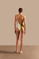 Model wearing the Solid AD Straps Bicolor Swimsuit showcasing the back of its pistachio colors, styled for a beach look.