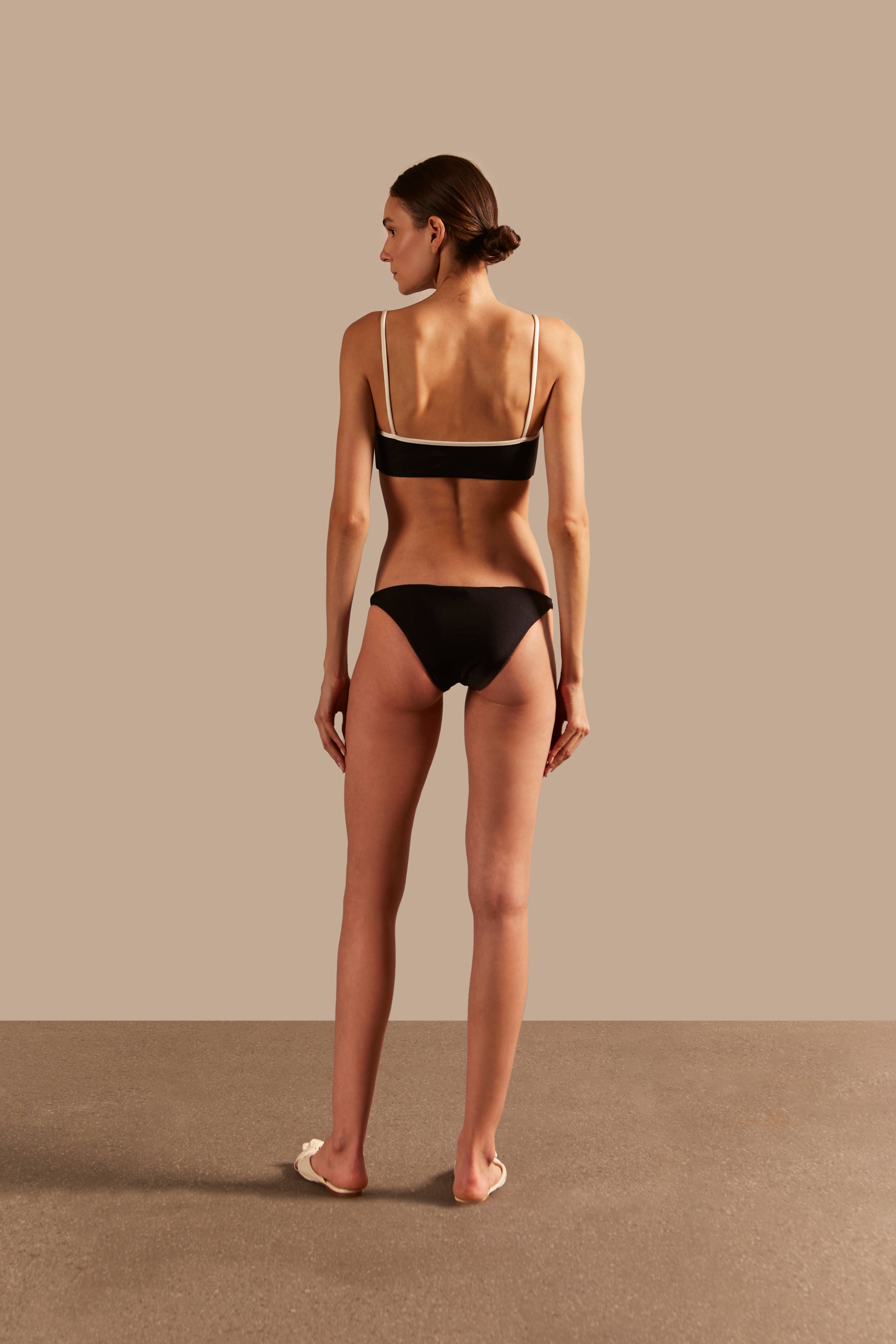 Model wearing the Solid AD Straps Bikini Back showcasing its Black and Off White color on 85% polyamide 15% elastane fabric.