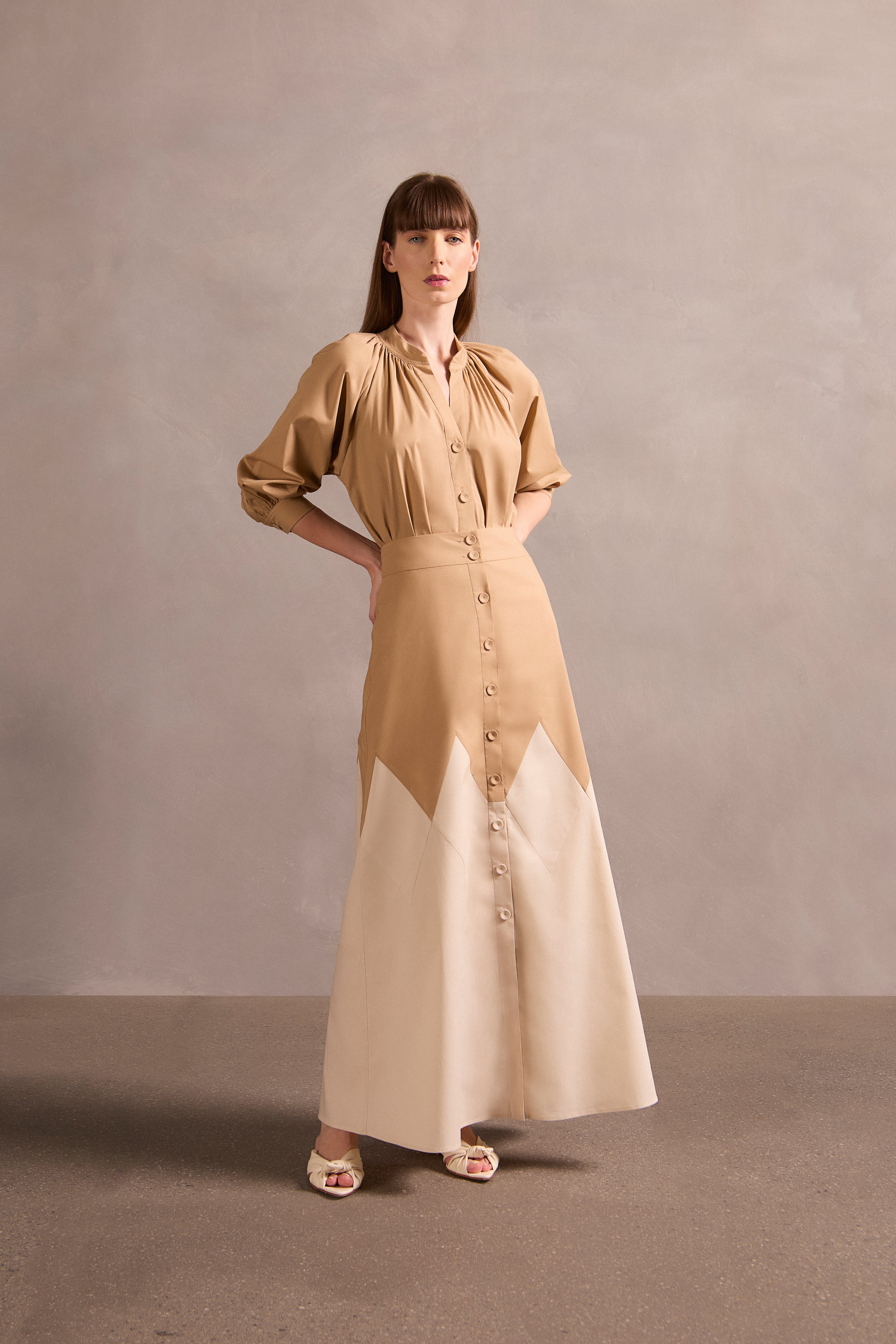 Model wearing the Solid Bicolor Long Skirt Front showcasing its Beige/Oat print on 98% Polyester 2% Elastane fabric, styled for an afternoon look.  