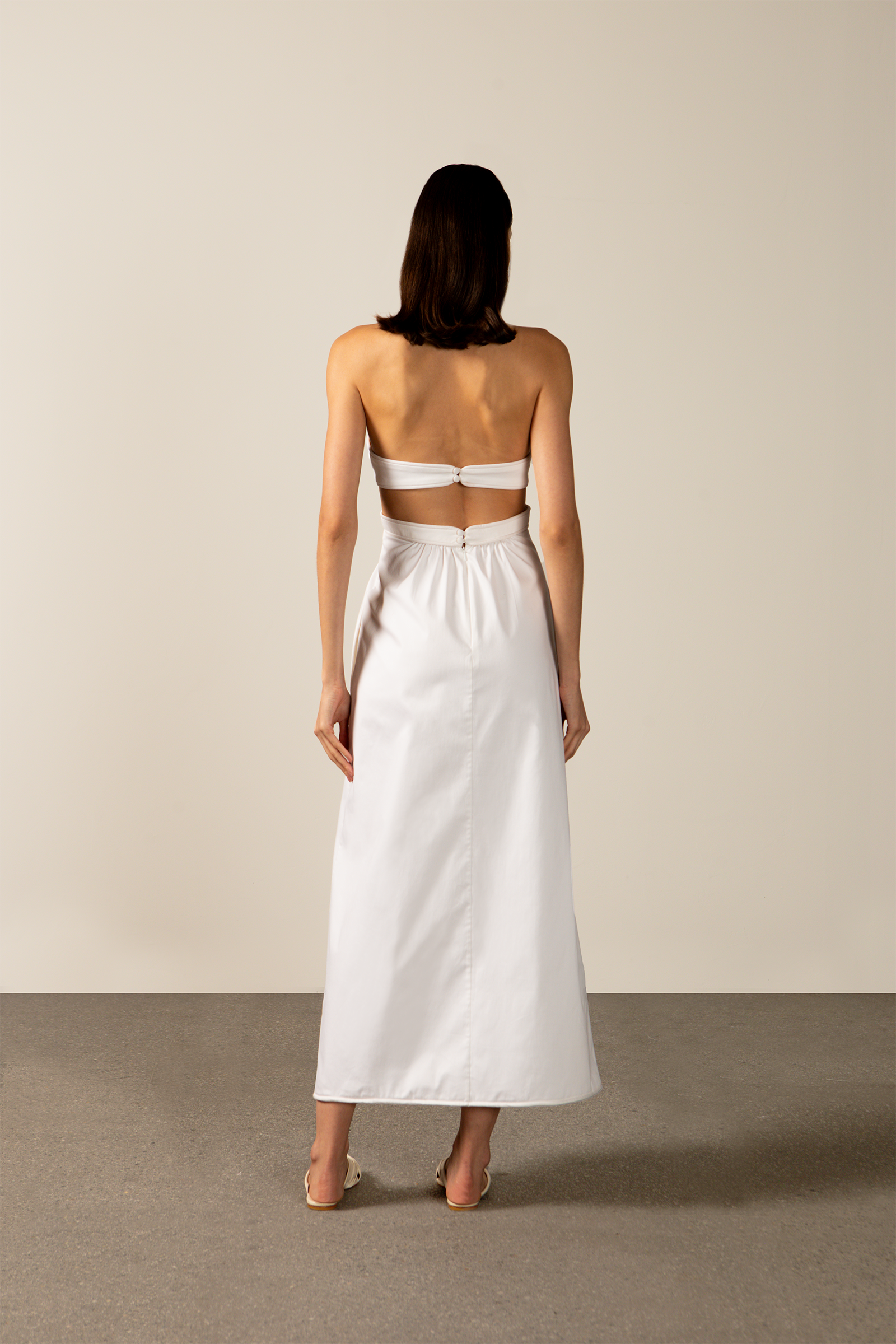 Model wearing the Solid Cut-Out Halterneck Long Dress Back showcasing its classic references with Off White print on 97% Cotton 03% Elastane fabric, styled for an afternoon look.