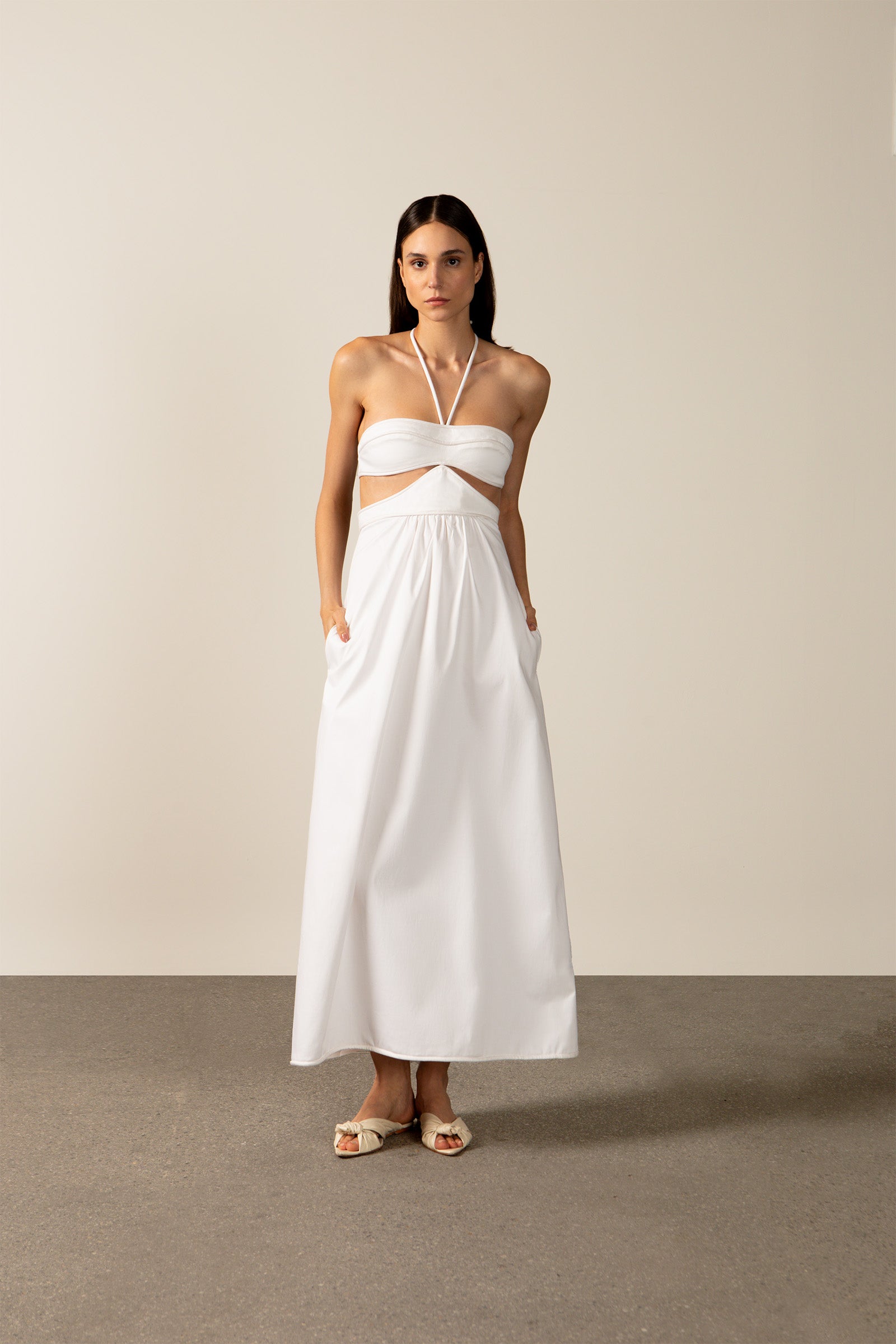 Model wearing the Solid Cut-Out Halterneck Long Dress Front showcasing its classic references with Off White print on 97% Cotton 03% Elastane fabric, styled for an afternoon look.