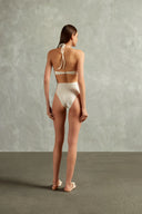 Model wearing the Solid Cut-Out Halterneck Swimsuit Back showcasing its Off White print on 85% polyamide 15% elastane fabric, styled for a beachwear look.