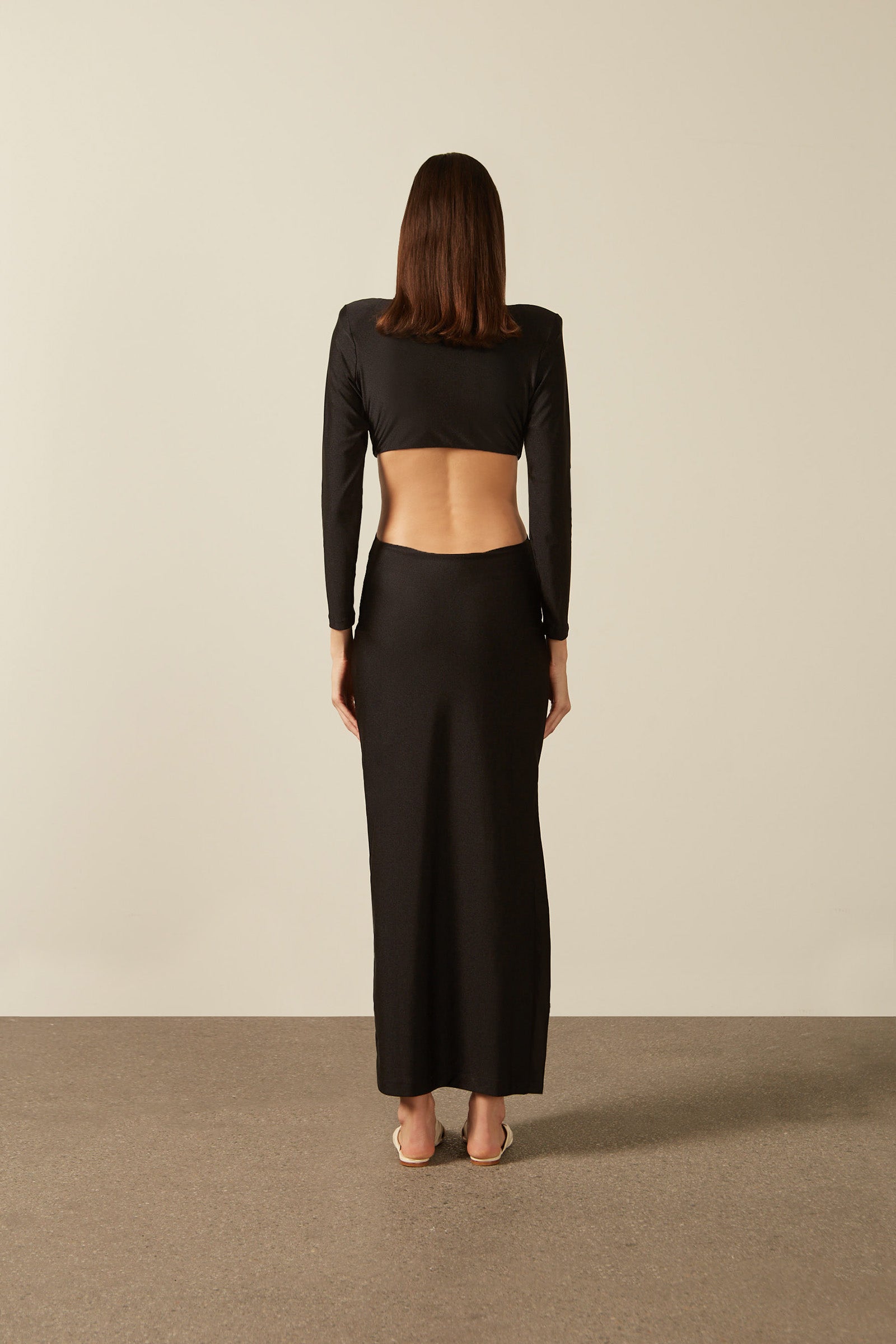 Model wearing the  Solid Cut-Out Long Dress Back showcasing its Black color on 85% Polyester 15% Elastane fabric, styled for an evening look.   