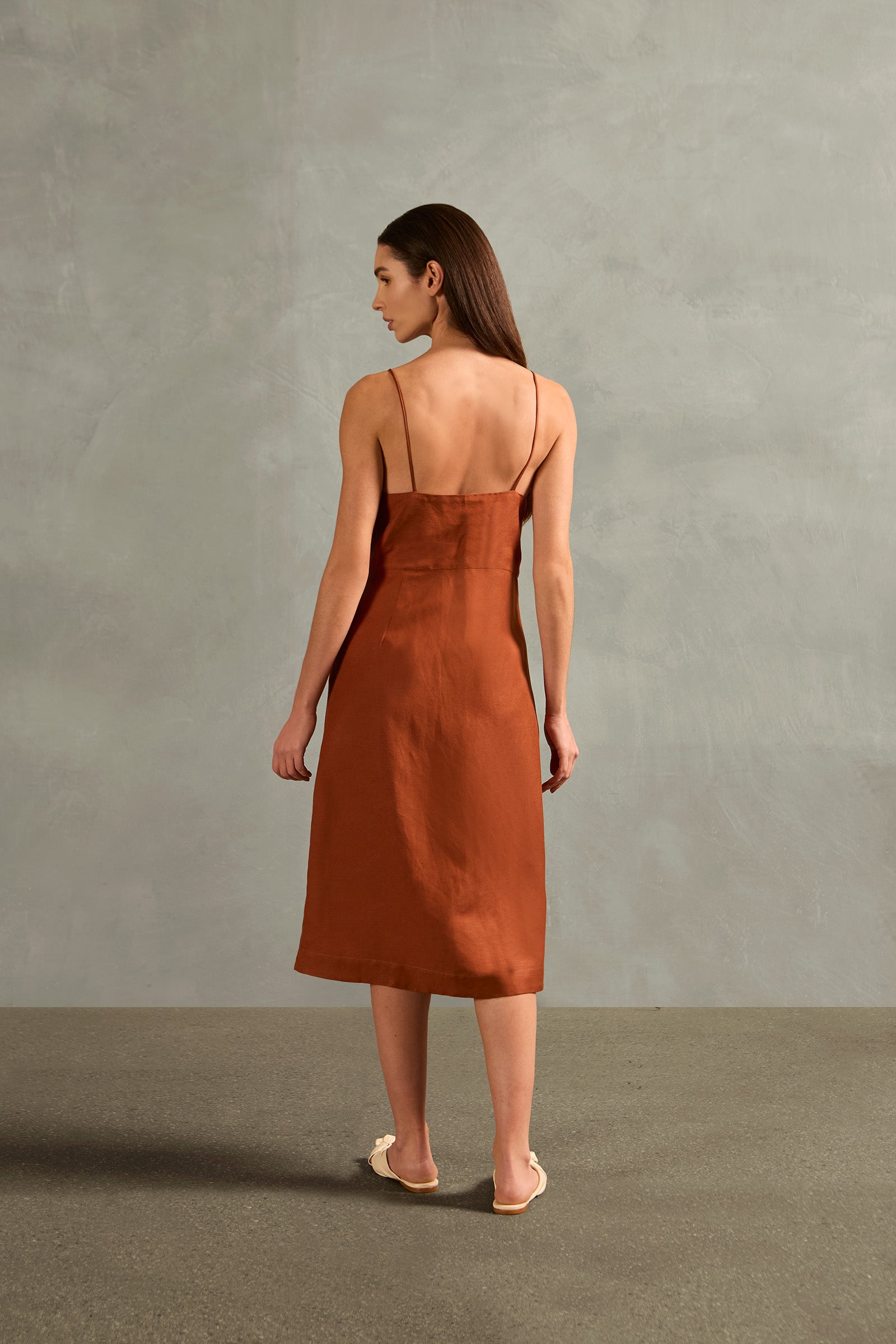 Model wearing the Solid Frilled Midi Dress Back showcasing its Cognac print on 55% Linen 45% Viscose fabric, styled for an afternoon look.