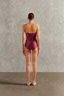 Model wearing the Solid Frilled Strapless Swimsuit Back showcasing its Magenta color on 85% polyamide 15% elastane fabric. 