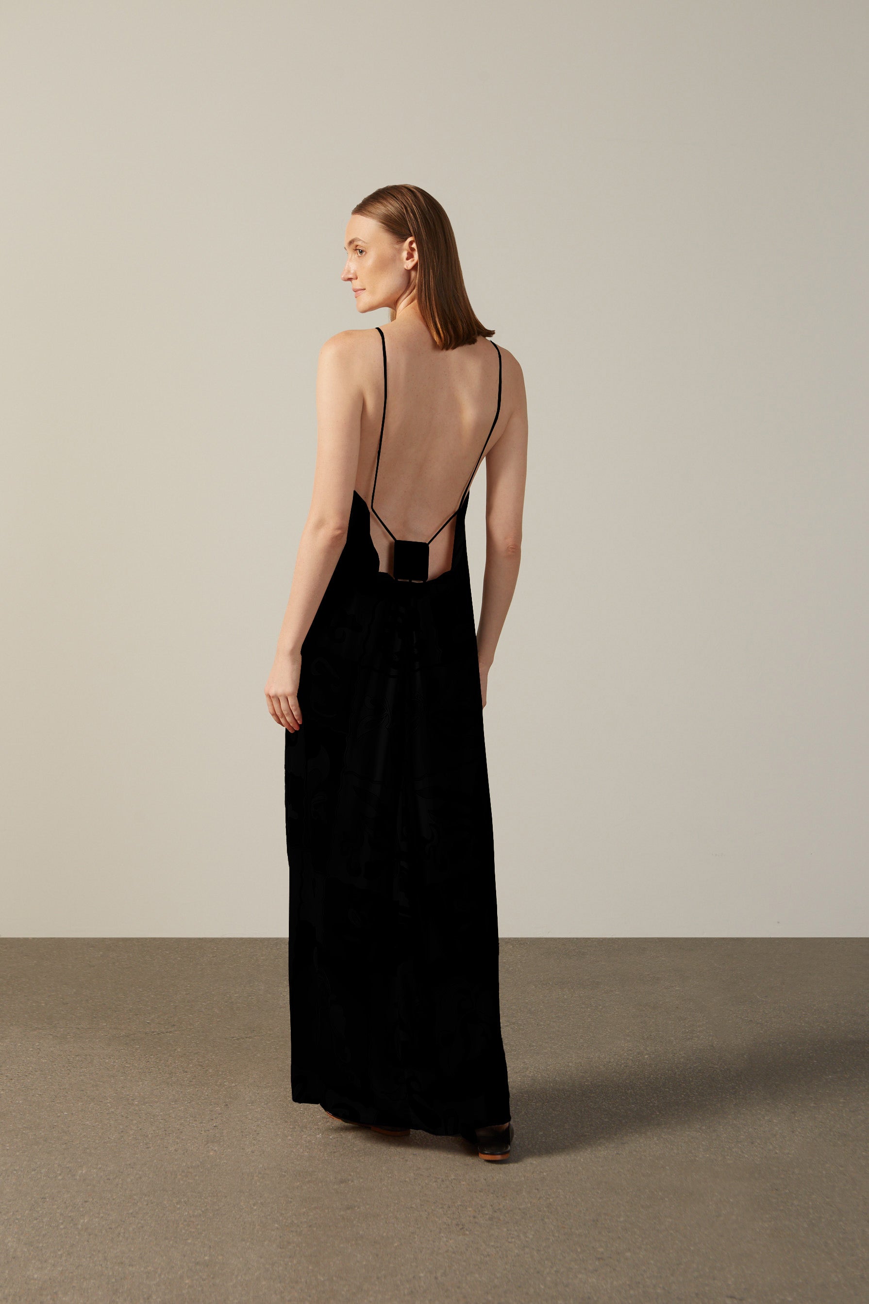 Model wearing the Solid Inamorata Bare-Back Long Dress Back showcasing its Black color on 100% Viscose fabric, styled for an evening look.  