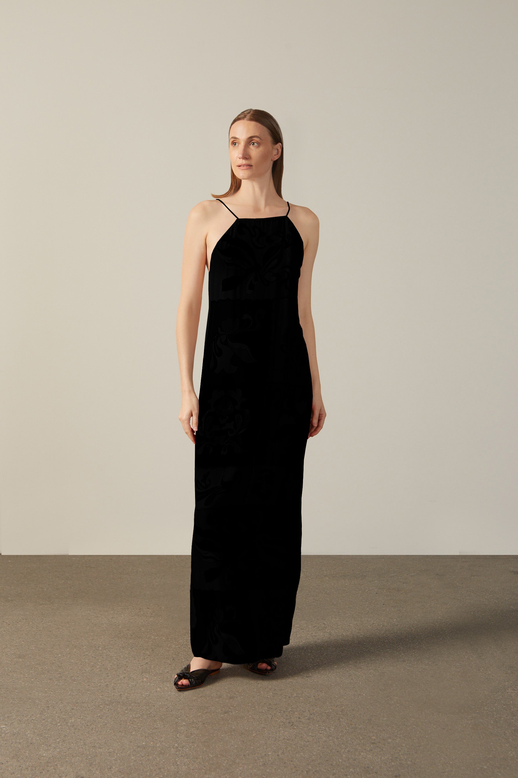 Model wearing the Solid Inamorata Bare-Back Long Dress Front showcasing its Black color on 100% Viscose fabric, styled for an evening look.  