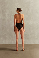 Model wearing the Solid Inamorata High-Waisted Nipple Bikini Back showcasing its Black color on 85% Polyamide 15% Elastane fabric, styled for a beachwear look. 