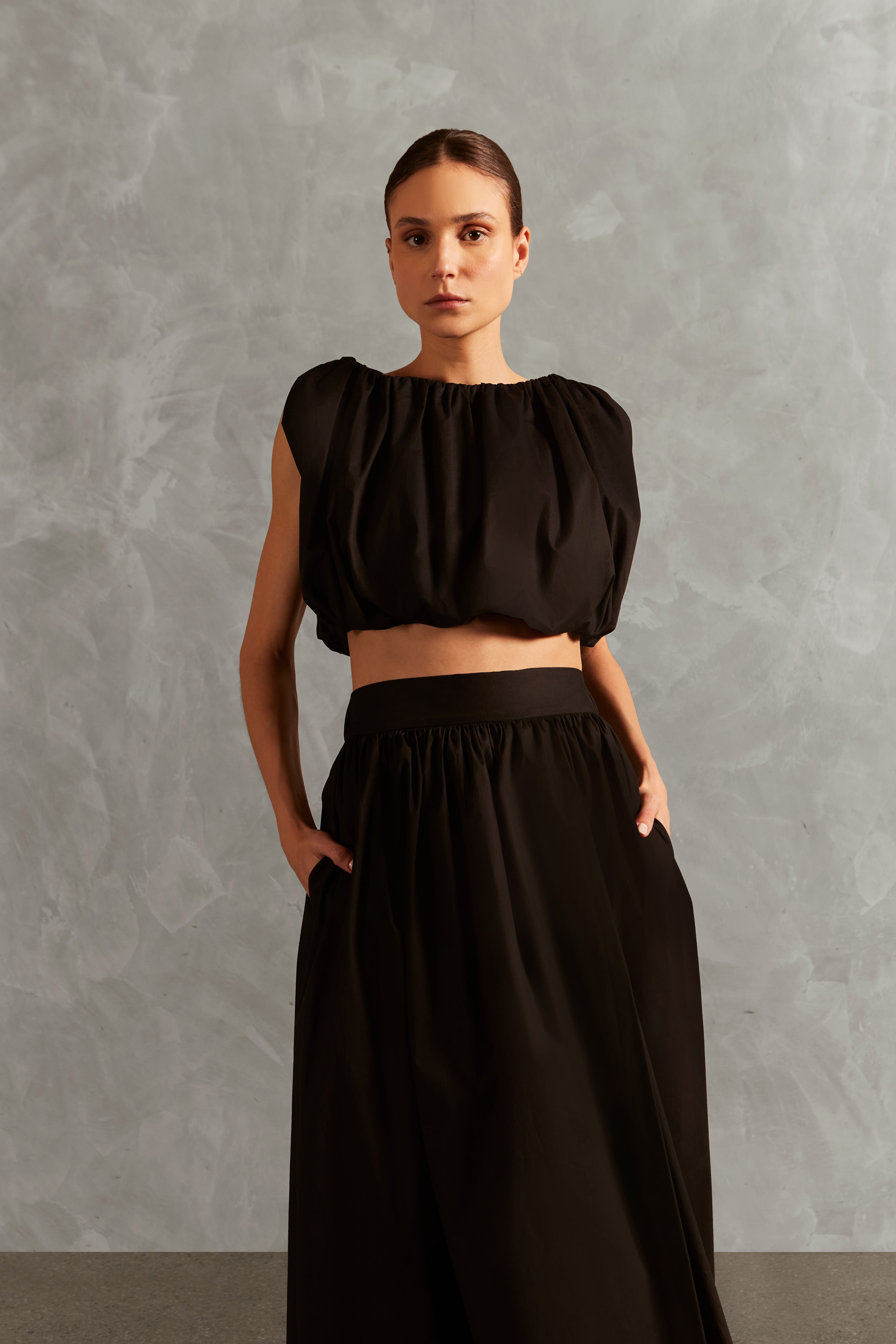 Model wearing the Solid Inamorata Side-Slit Long Skirt Detail showcasing its Black color on 98% Cotton 2% Elastane fabric, styled for an afternoon look. 