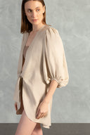 Model wearing the Solid Shirt With Voluminous Sleeves color sand detail with 100% linen fabric, styled for a resort look. 