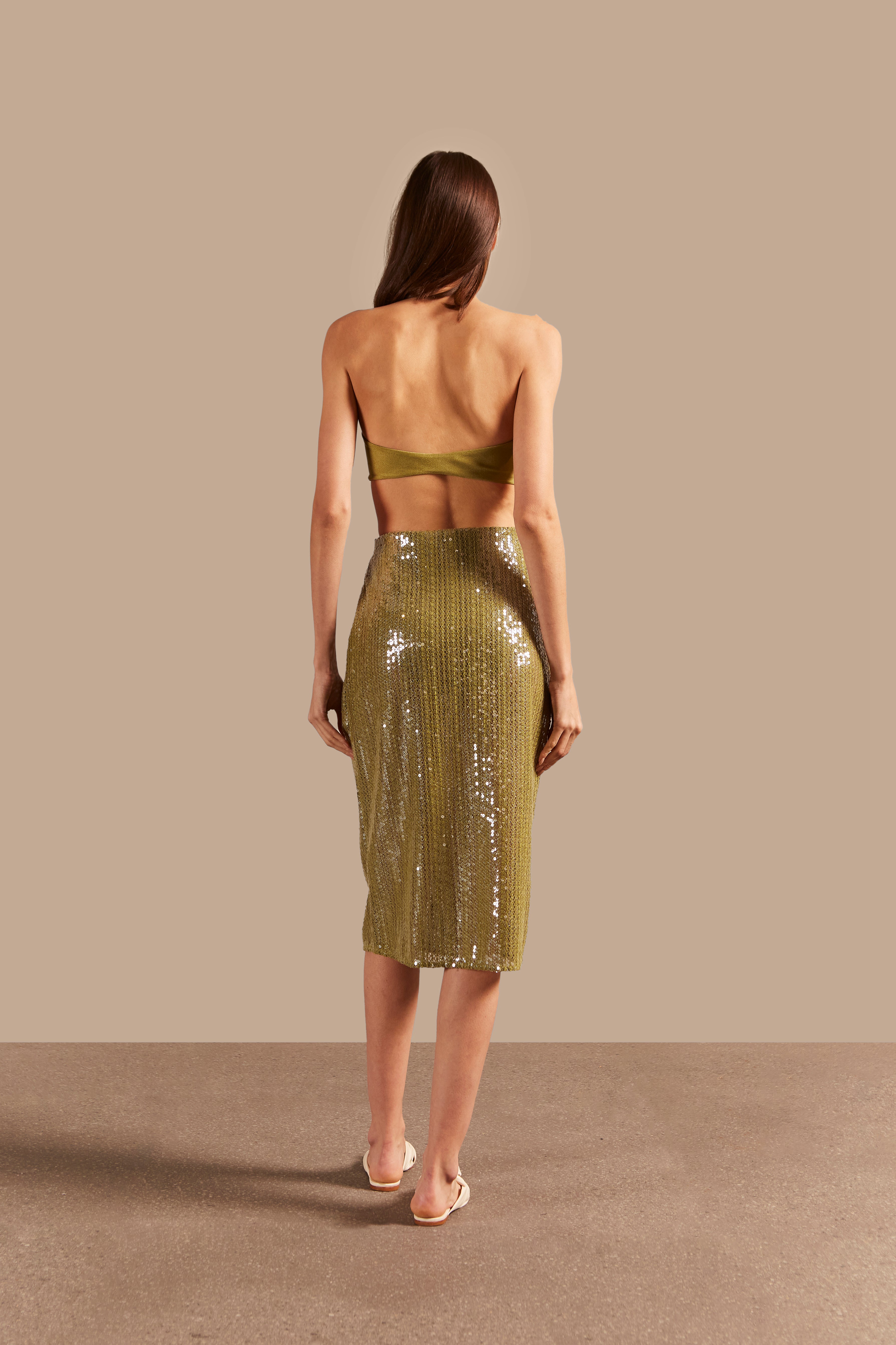 Model wearing the Solid Sequins Midi Skirt Back showcasing its Pistachio print on 85% Polyester 15% Cotton fabric, styled with strapless top for a casual look.
