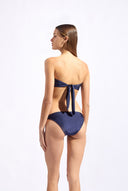 Model wearing the Solid Bandeau Bikini back color navy made from 85% plyamide 15% elastane, styled for a beachwear look