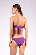Model wearing the Solid Bandeau Bikini back color purple made from 85% plyamide 15% elastane, styled for a beachwear look