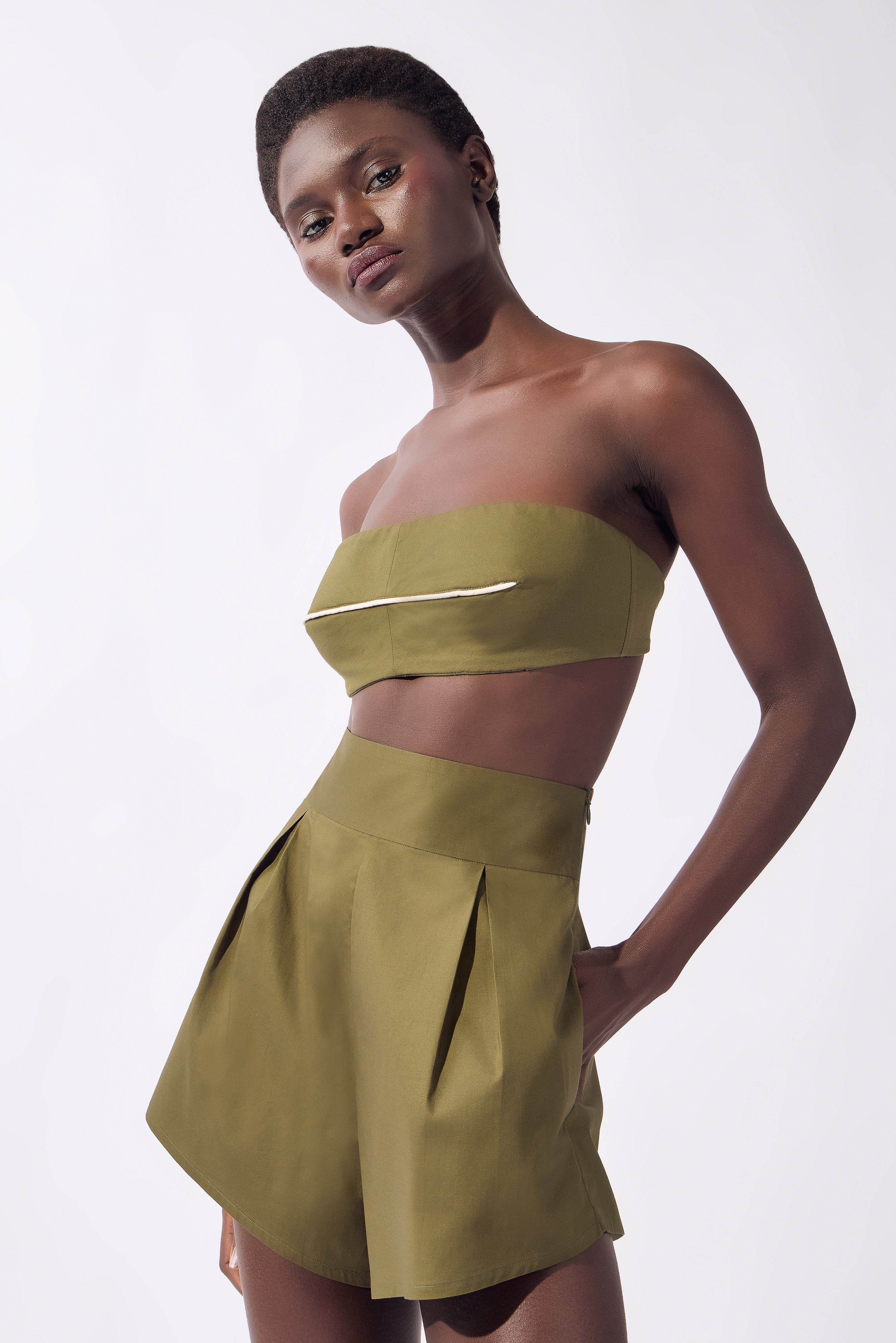 Model wearing the Solid Bandeau Top detail color green, made from 98% cotton 2% elastane, styled for a resort look