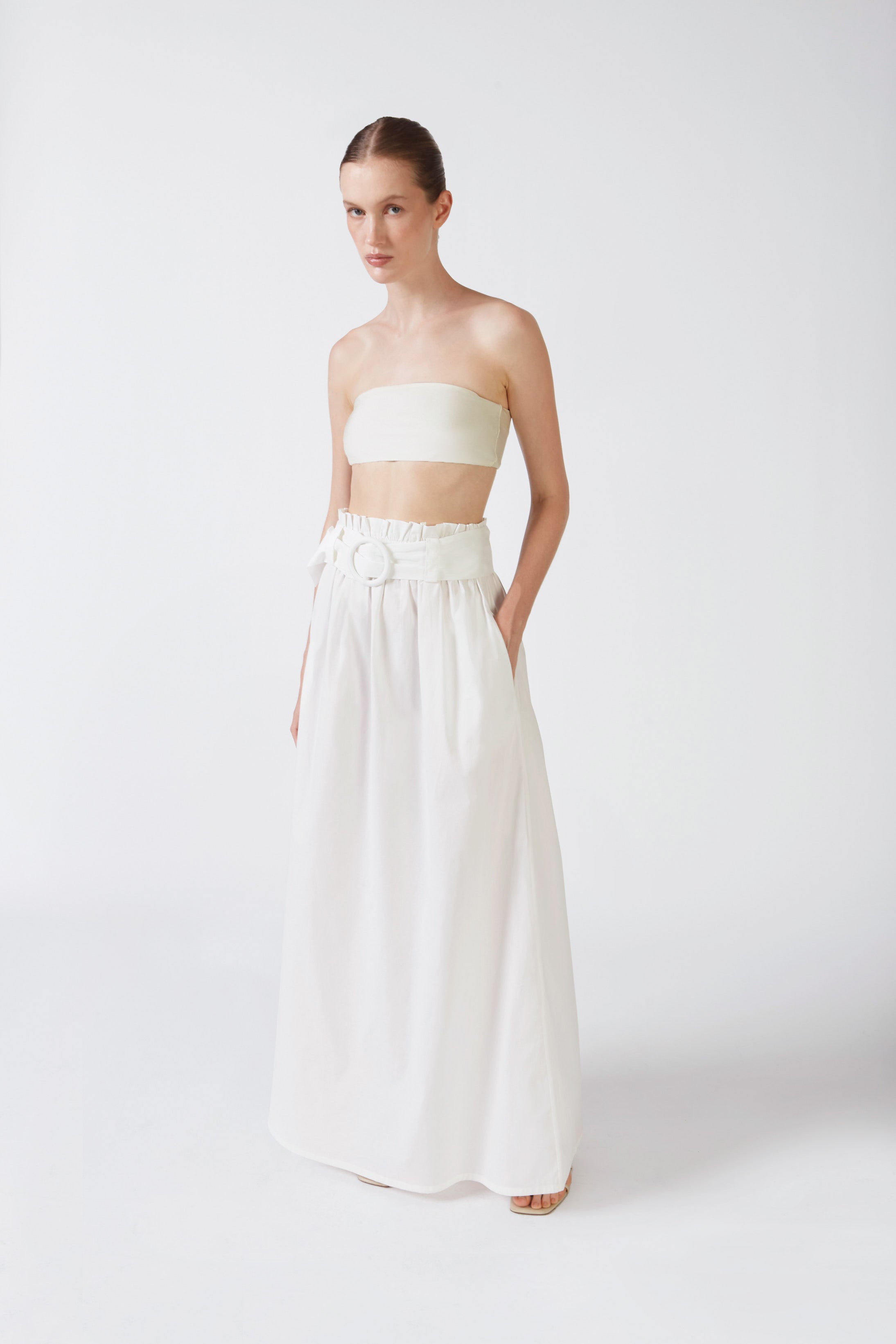 Model wearing the Solid Belted Long Skirt color off white styled for a resort look.