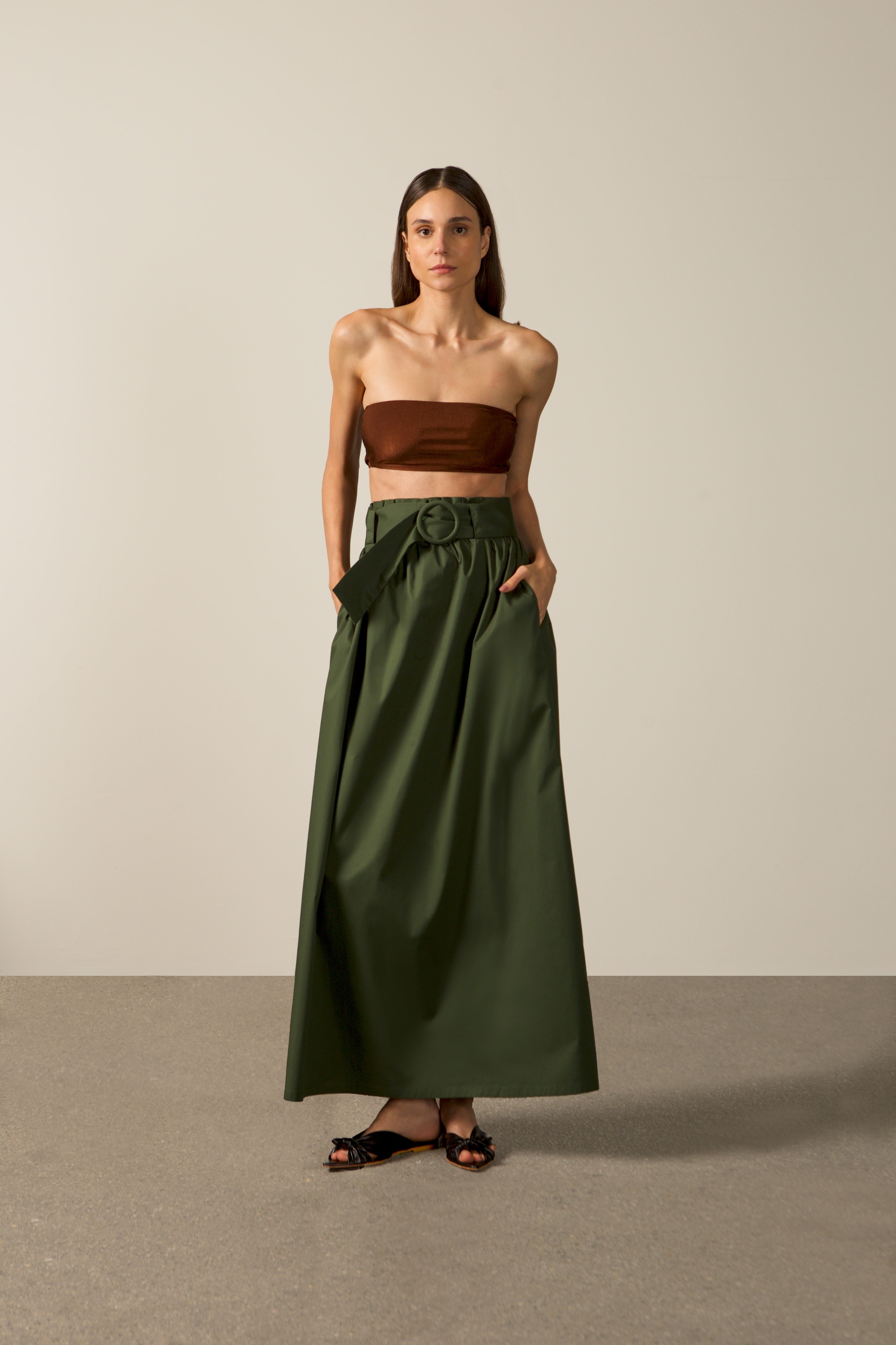 Model wearing the Solid Belted Long Skirt color dark green styled for a resort look.