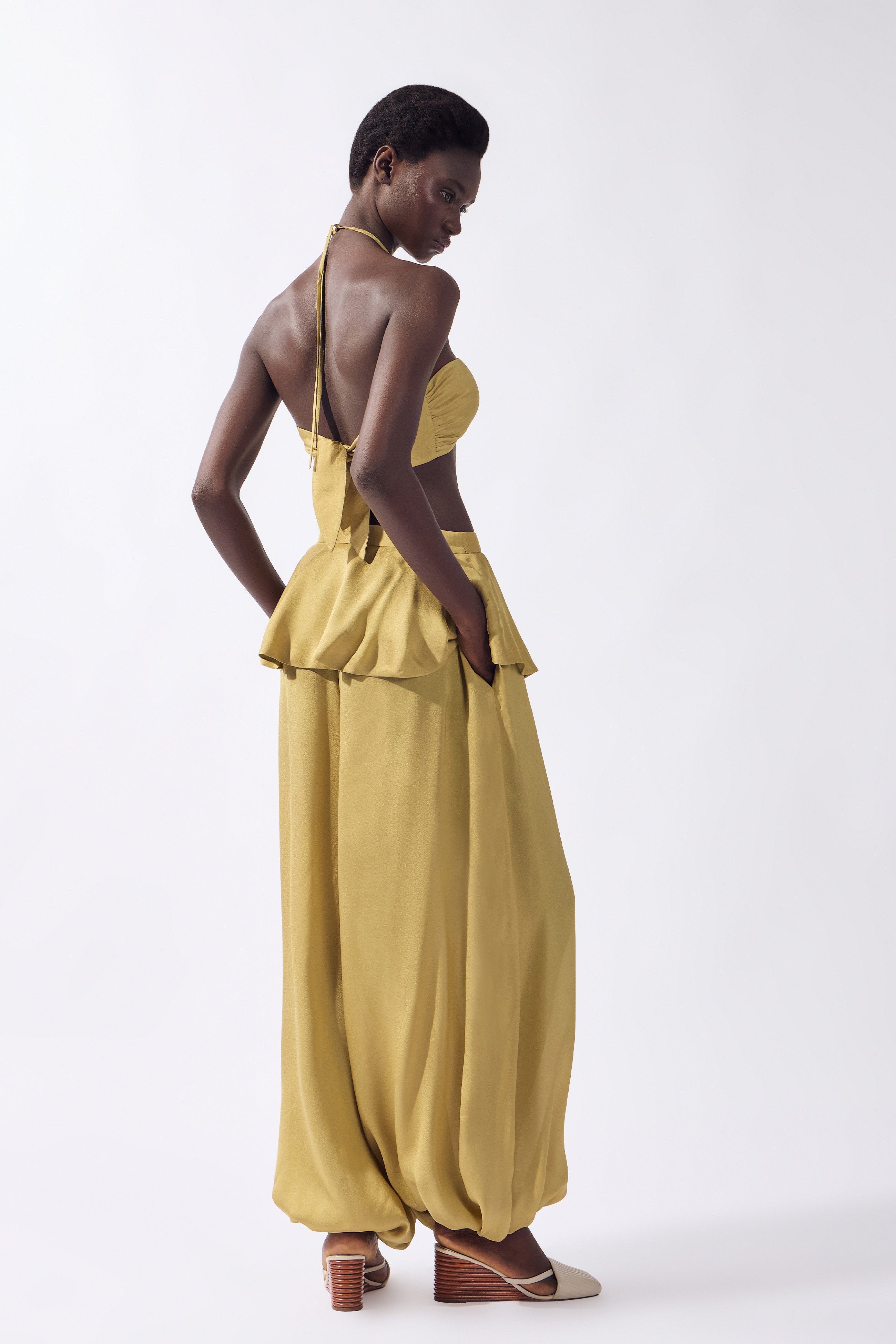 Model wearing the Solid Bubble Pants back color pistachio, made from 100% viscose, styled for an afternoon look