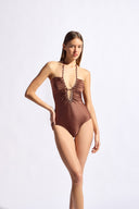 Model wearing the Solid Chain Halterneck Swimsuit color cappuccino made from 85% polyamide 15% elastane, styled for a beachwear look