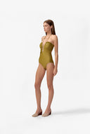 Model wearing the Solid Chain Halterneck Swimsuit color pistache made from 85% polyamide 15% elastane, styled for a beachwear look