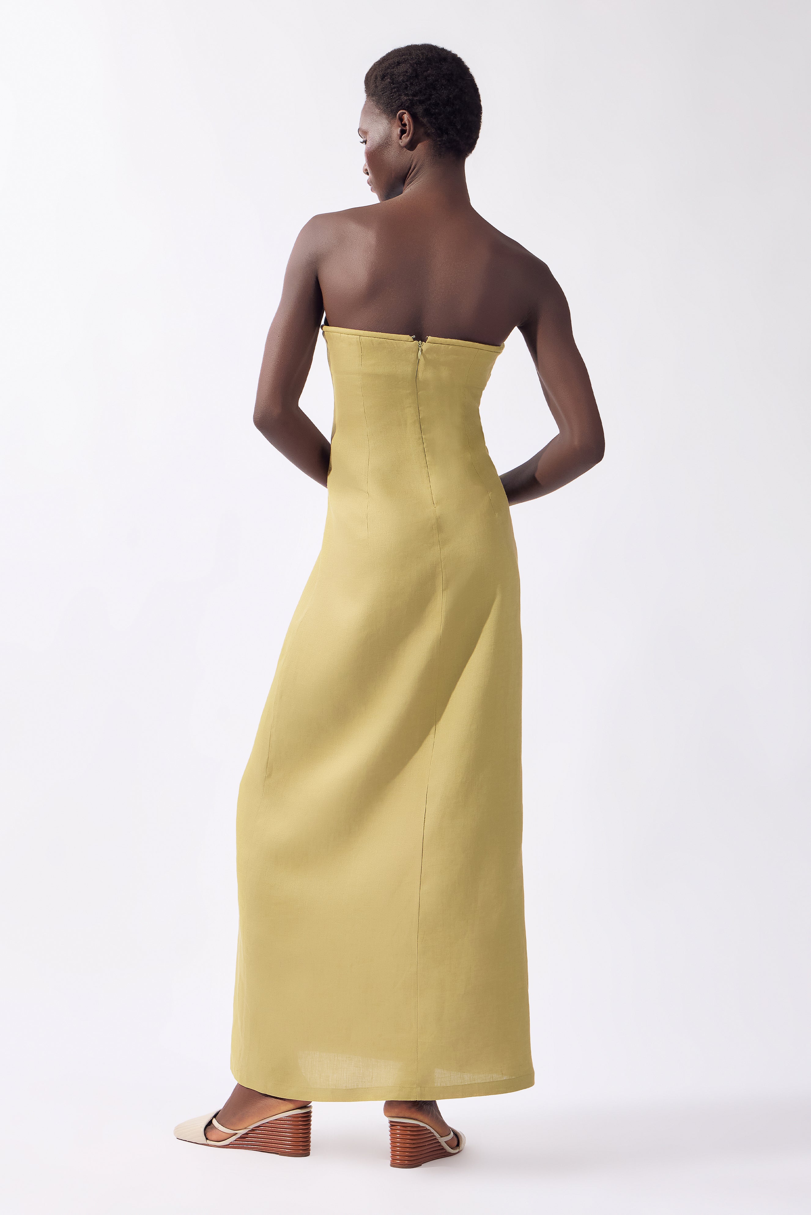 Model wearing the Solid Corset Maxi Dress back color pistachio, made from 100% linen, styled for night look  