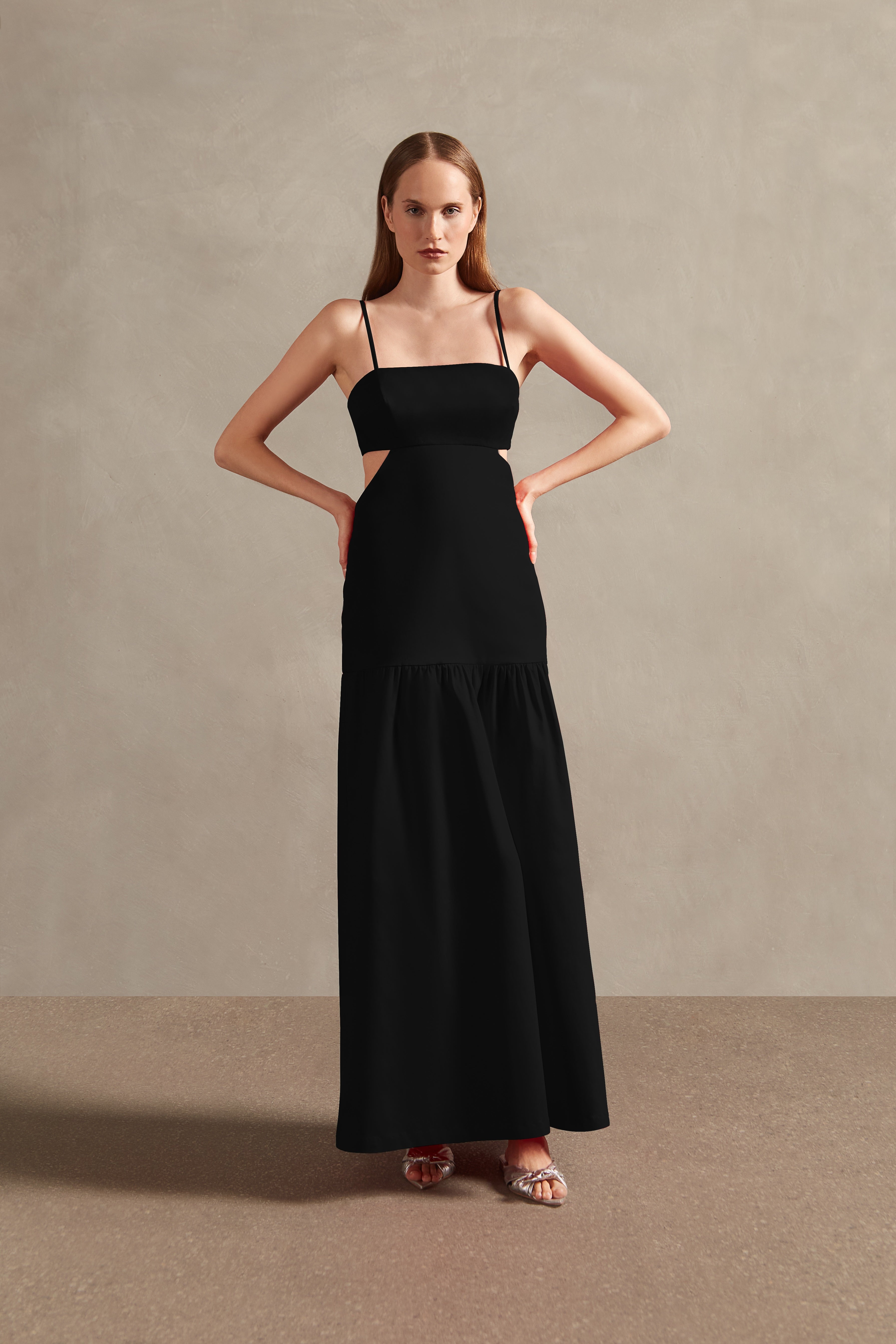 Model wearing the Solid Cut-Out Long Dress color black front with 97% cotton 3% elastane fabric, styled for a resort look