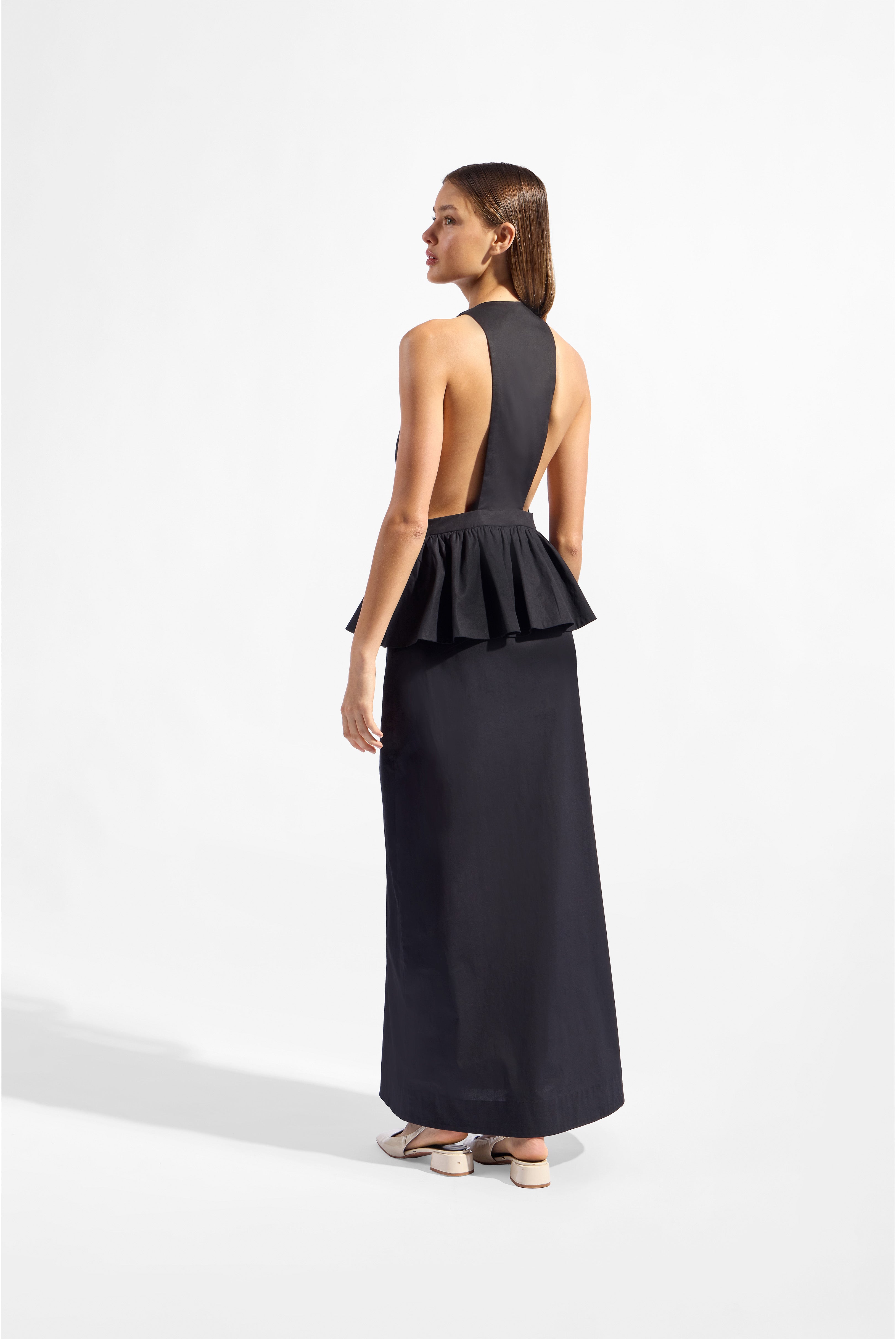 Model wearing the Solid Deep V-Neck Peplum Maxi Dress back color black made with 97% Cotton 3% Elastane, styled for resortwear look