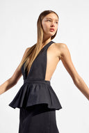 Model wearing the Solid Deep V-Neck Peplum Maxi Dress detail color black made with 97% Cotton 3% Elastane, styled for resortwear look