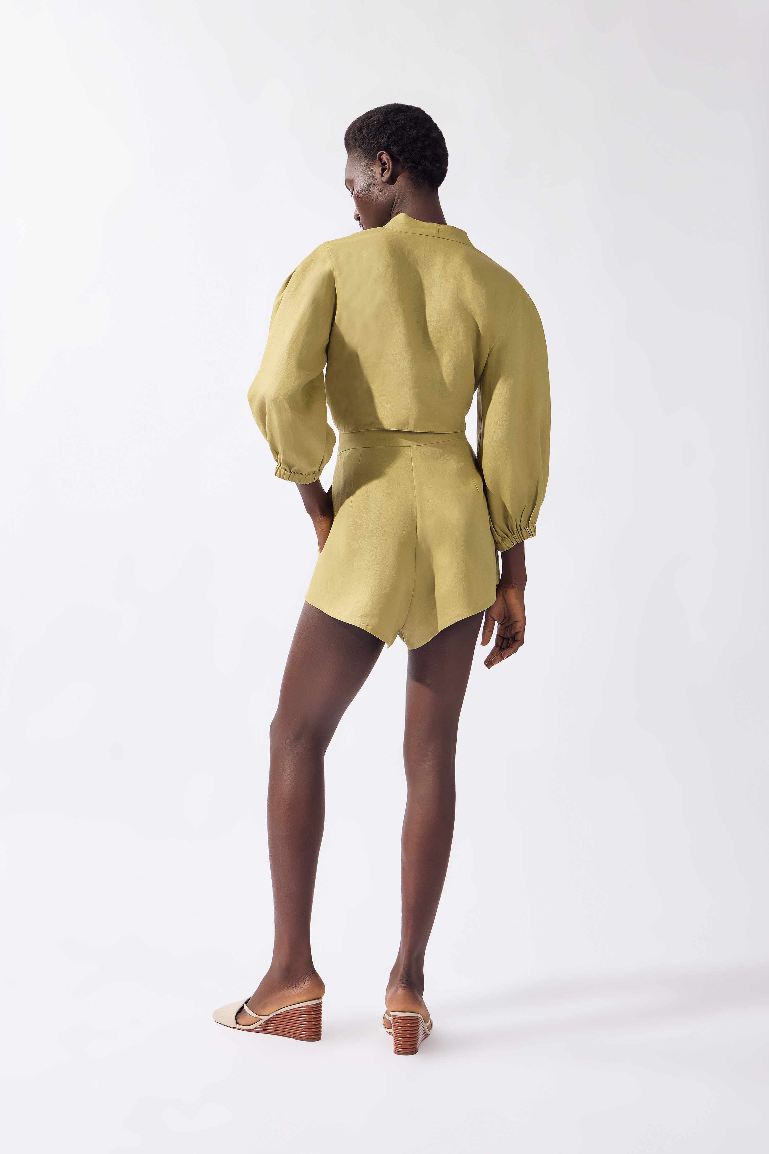 Model wearing the Solid Front-Tie Crop Top back color pistachio, made from 100% linen, styled for a resort look